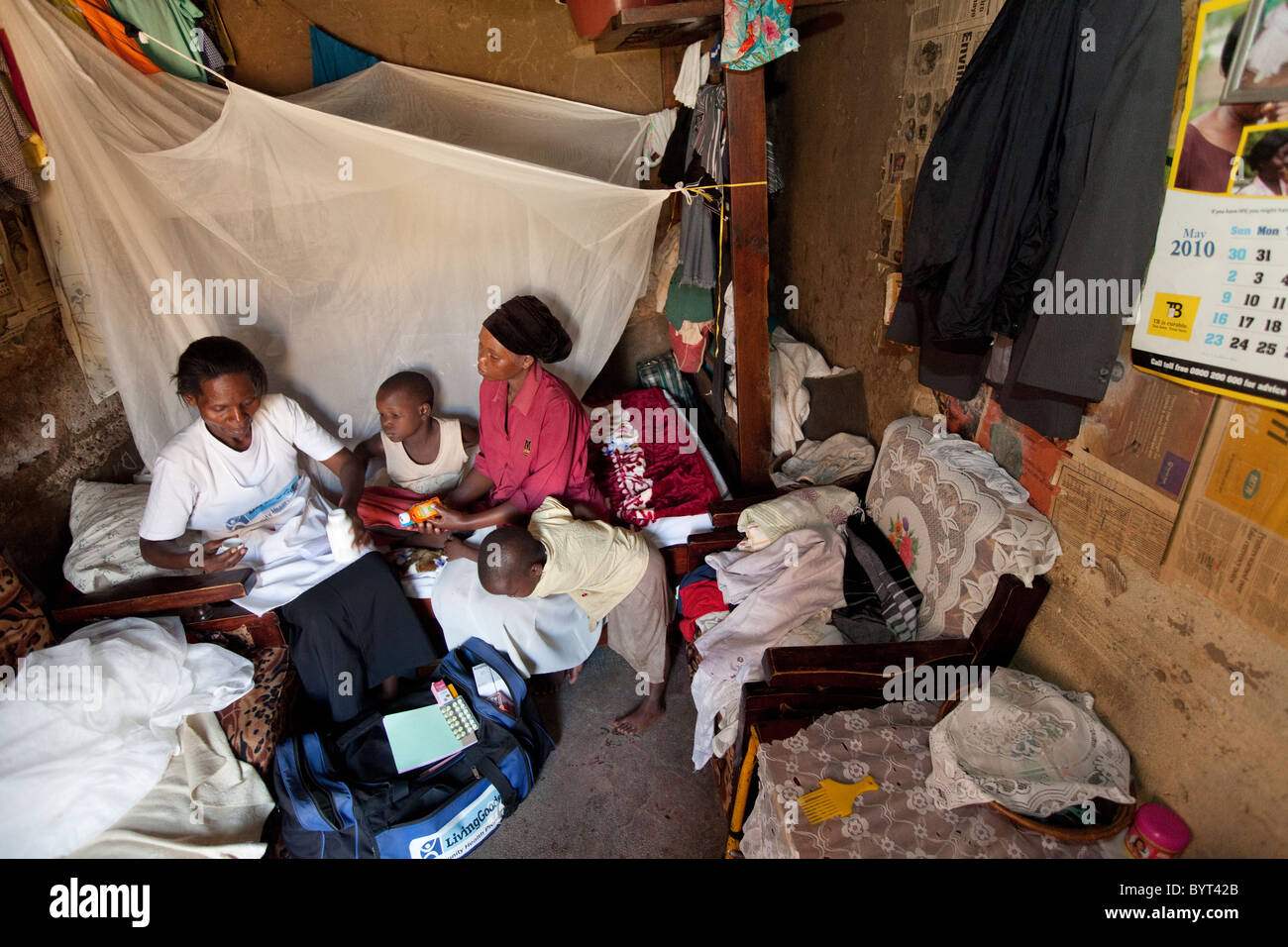Ein Gemeindearbeiter Gesundheitswesen Outreach besucht eine HIV positive Familie in einem Slum in Kampala, Uganda, Ostafrika. Stockfoto