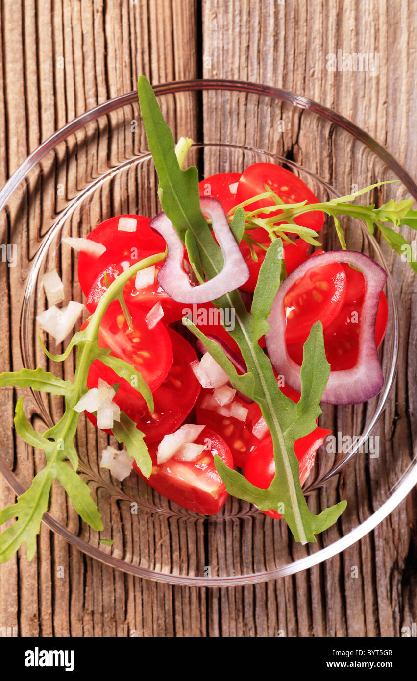 Frischer Tomatensalat mit Zwiebel und Rucola Stockfoto