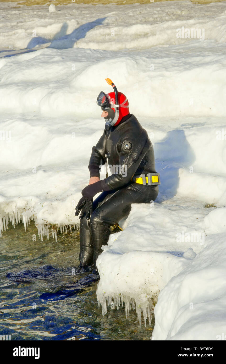 Taucher im Wasser auf dem weißen Eis im winter Stockfoto