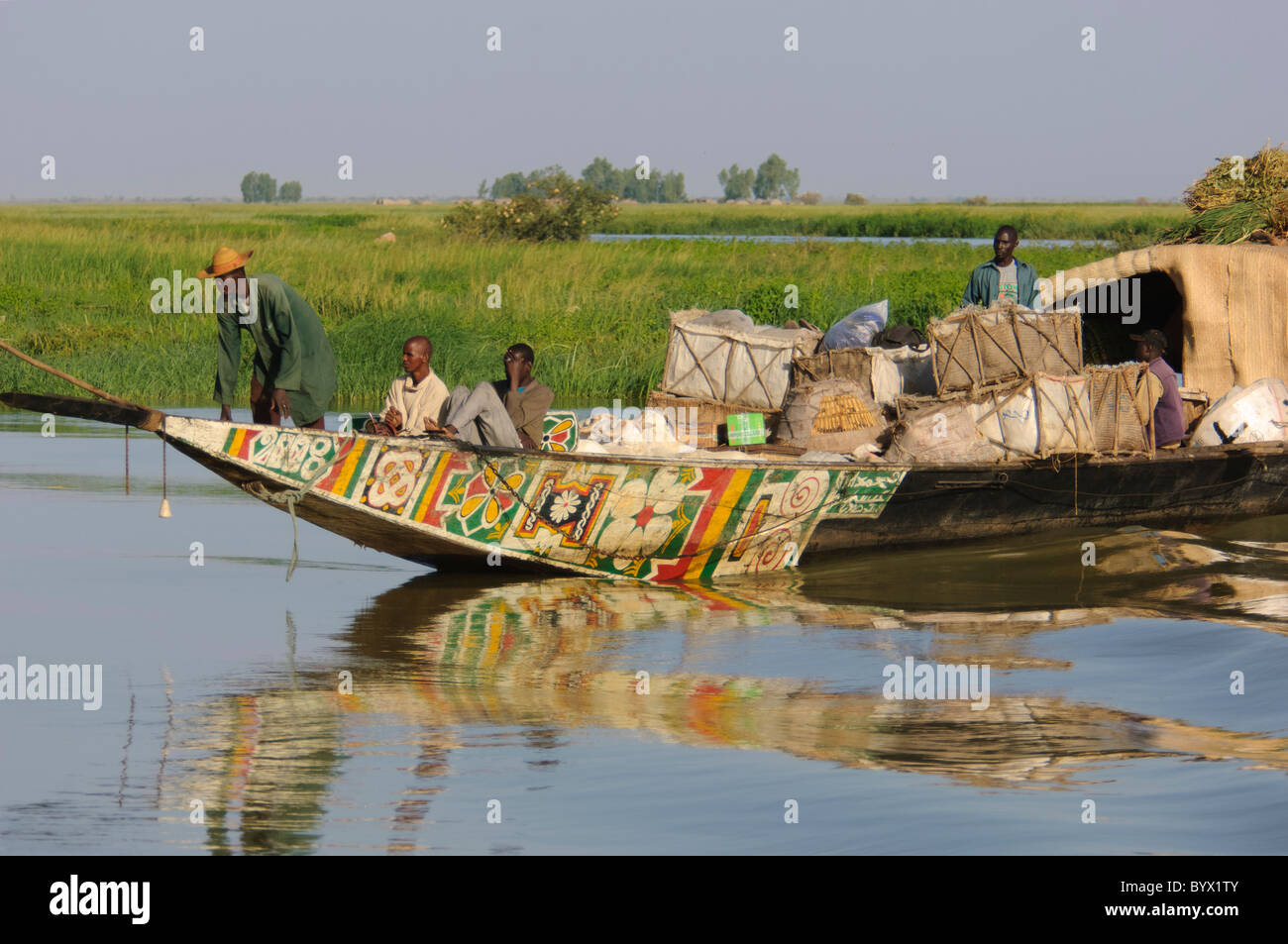 Passagiere und Steuermann sitzt auf der Vorderseite eine Transport-Pinasse, kreuzen die Niger-Binnendelta. Mali. Stockfoto