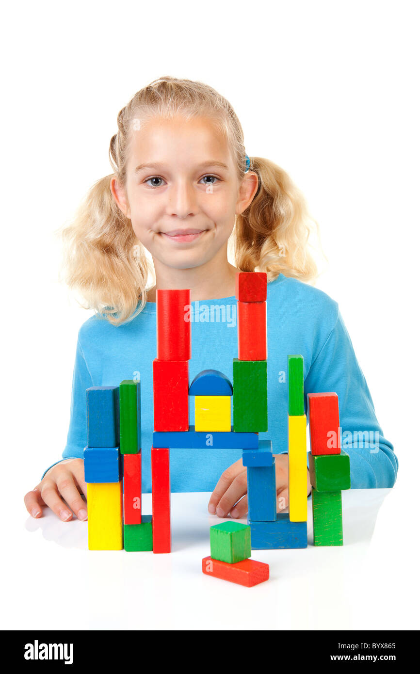 Junges blondes Mädchen spielt mit bunten Holzklötze auf weißem Hintergrund Stockfoto