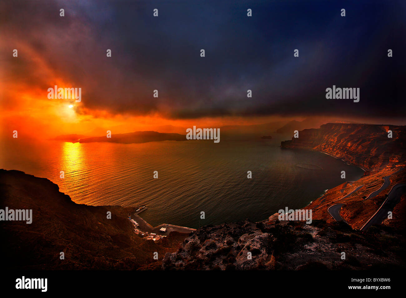 Sonnenuntergang in Santorini, rechts oben Athinios Hafen, mit Blick zum großen Teil der Caldera unter schlechten Wetterbedingungen. Griechenland Stockfoto