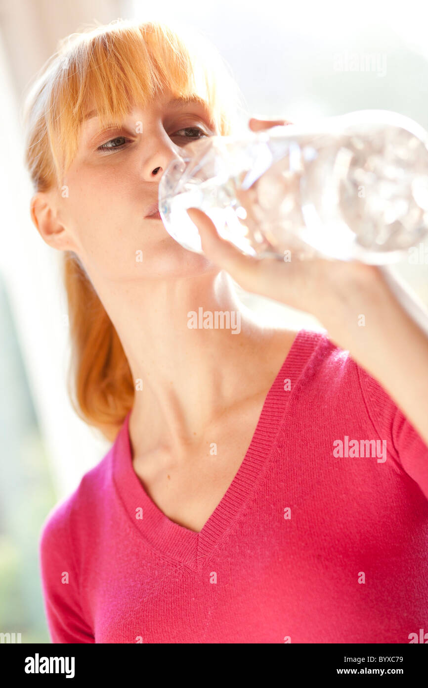 Frau trinkt Mineralwasser Stockfoto