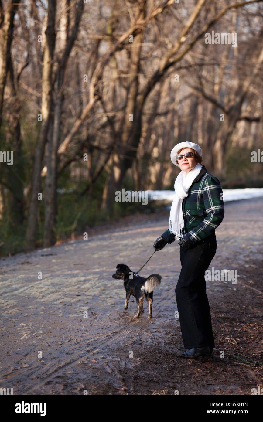 Porträt von senior Woman walking Hund Stockfoto