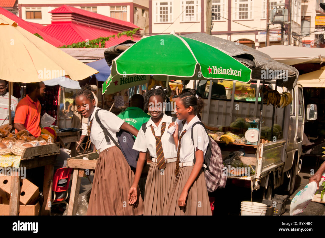 Schulmädchen in Uniform am produzieren Stand in der Innenstadt von St Georges, Grenada, Östliche Karibik Stockfoto