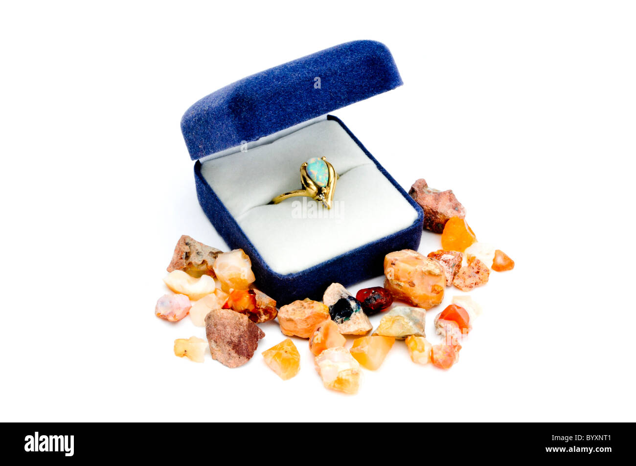 Opal ring in gold Einstellung im blauen Kasten umgeben von rohe Edelsteine Stockfoto