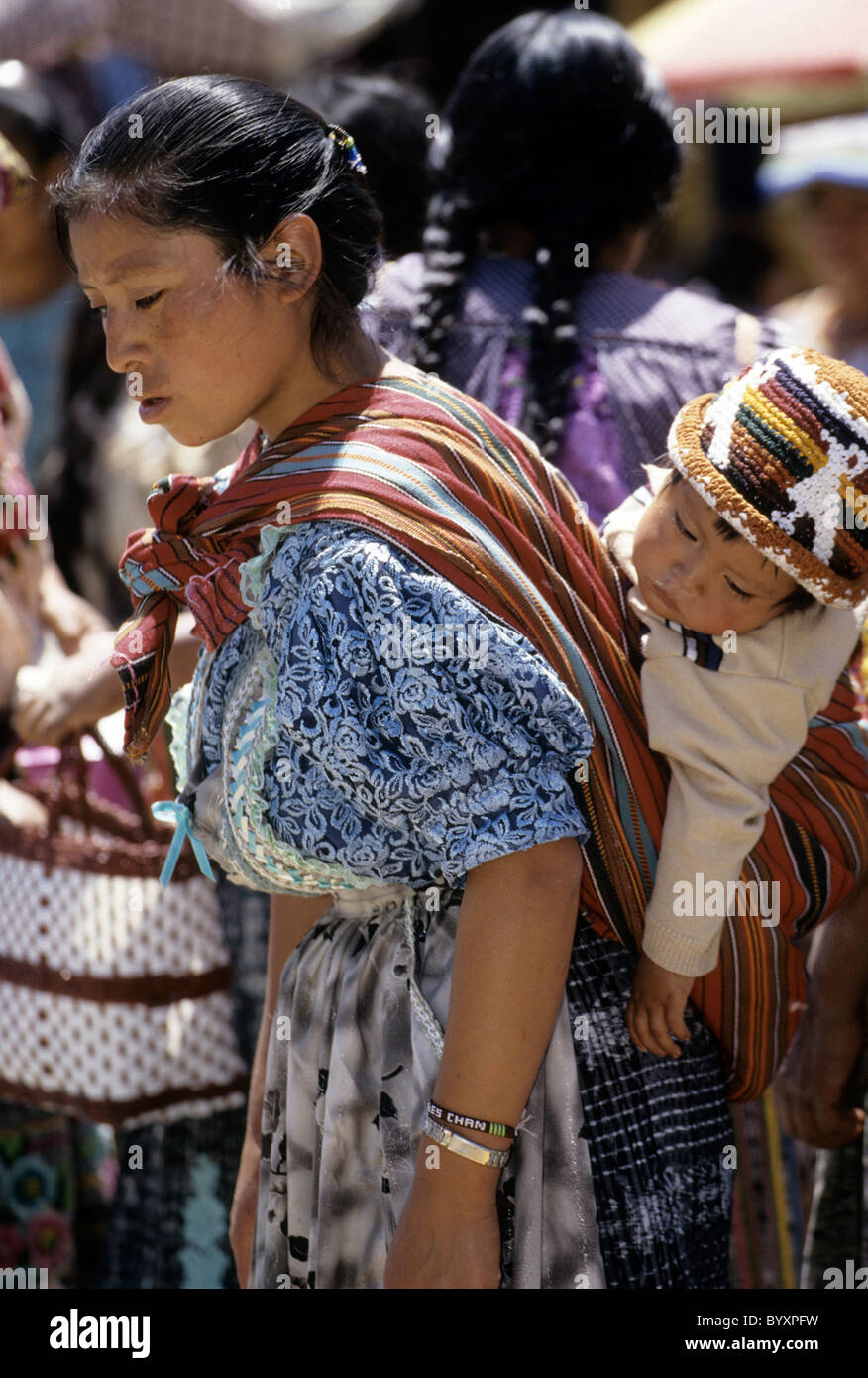 Traditionell gekleidete Frauen wandern vor bunten Kirche-San Andres Xecul, Guatemala. Stockfoto