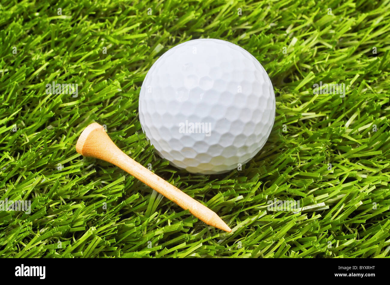 Golfball und Abschlag auf dem grünen Rasen. Stockfoto