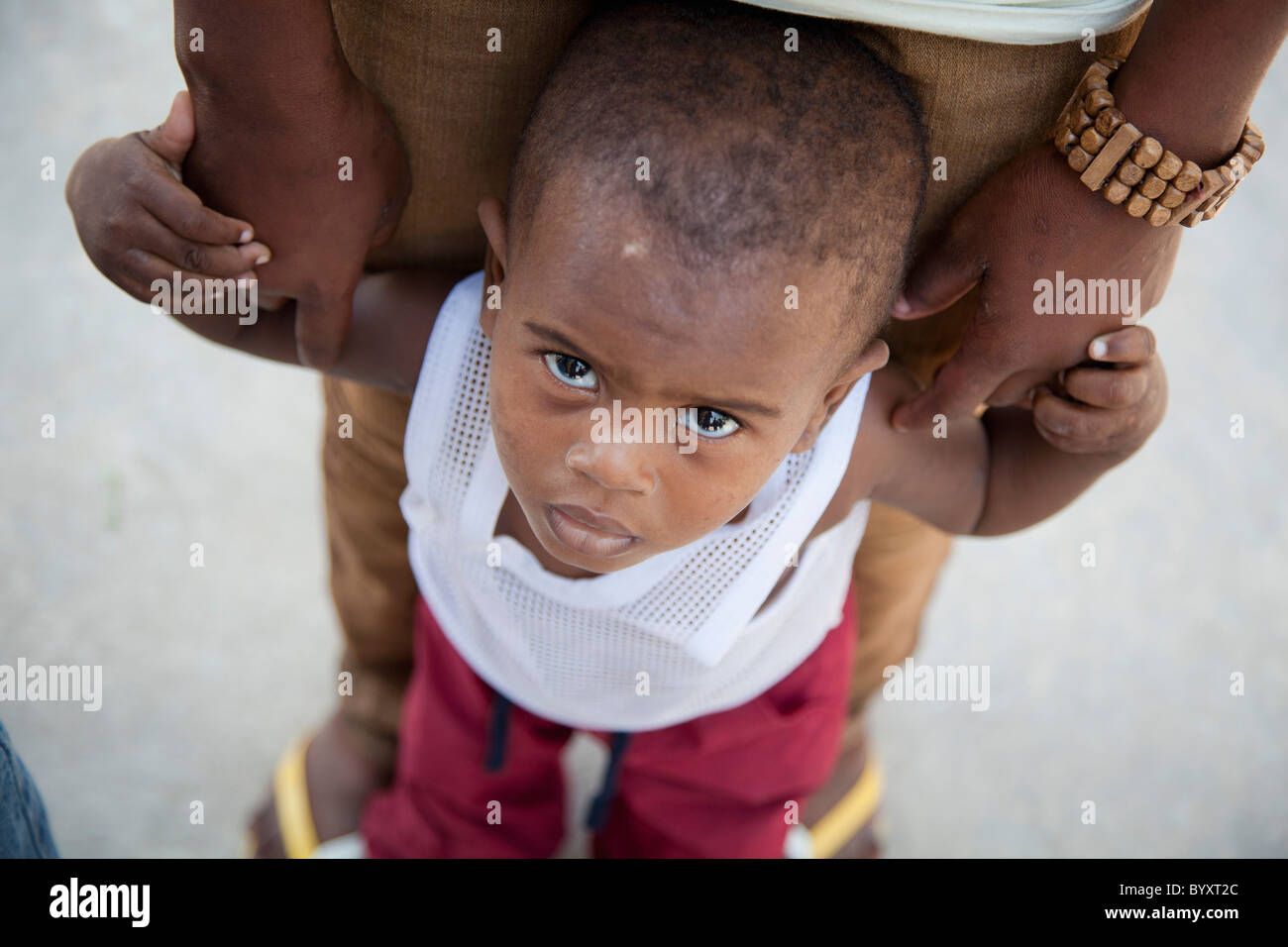 ein kleiner Junge hält sich an seine Mutter Hände; Grand Saline, haiti Stockfoto