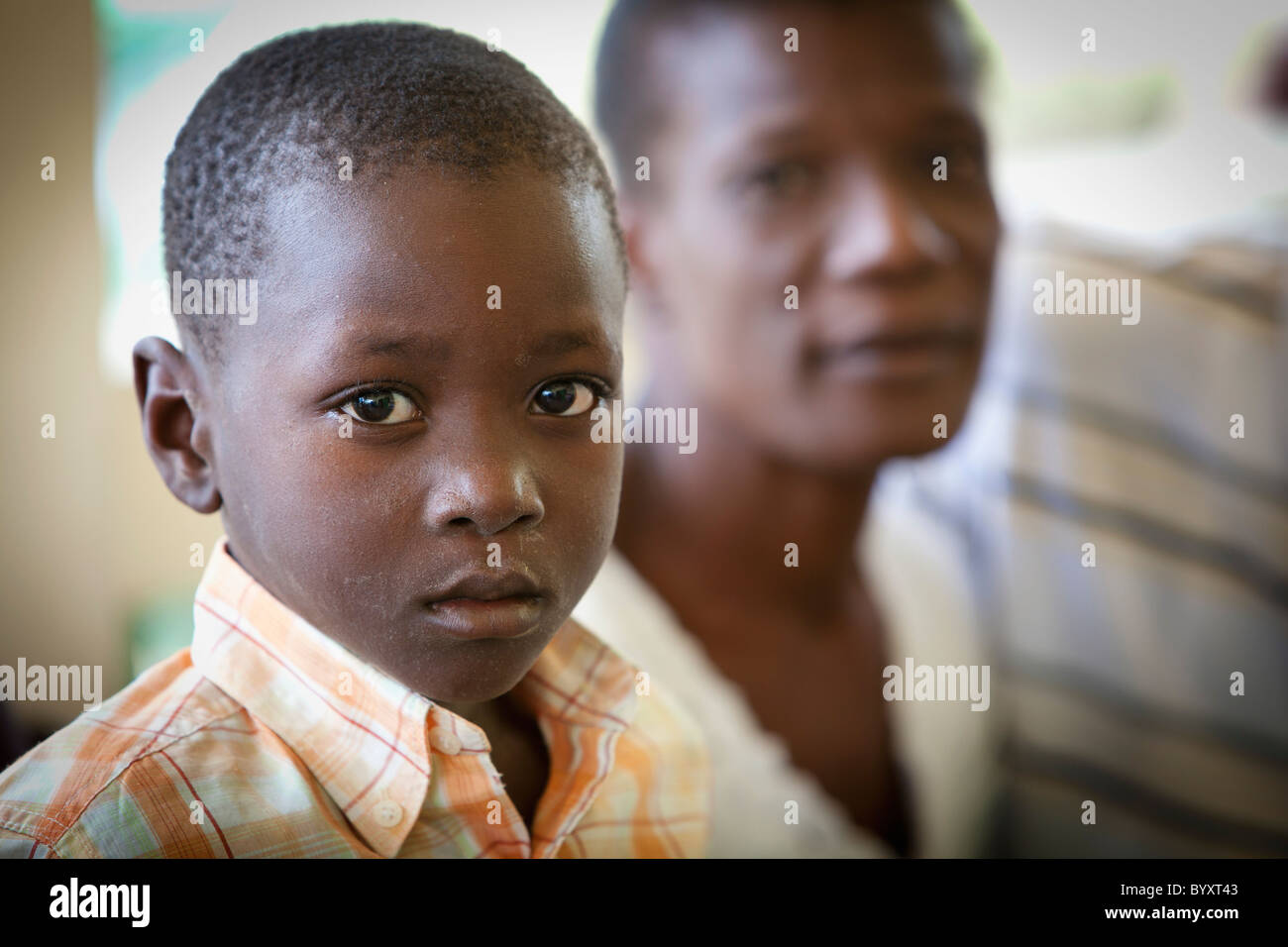 ein Junge sitzt neben seinem Vater; Grand Saline, haiti Stockfoto