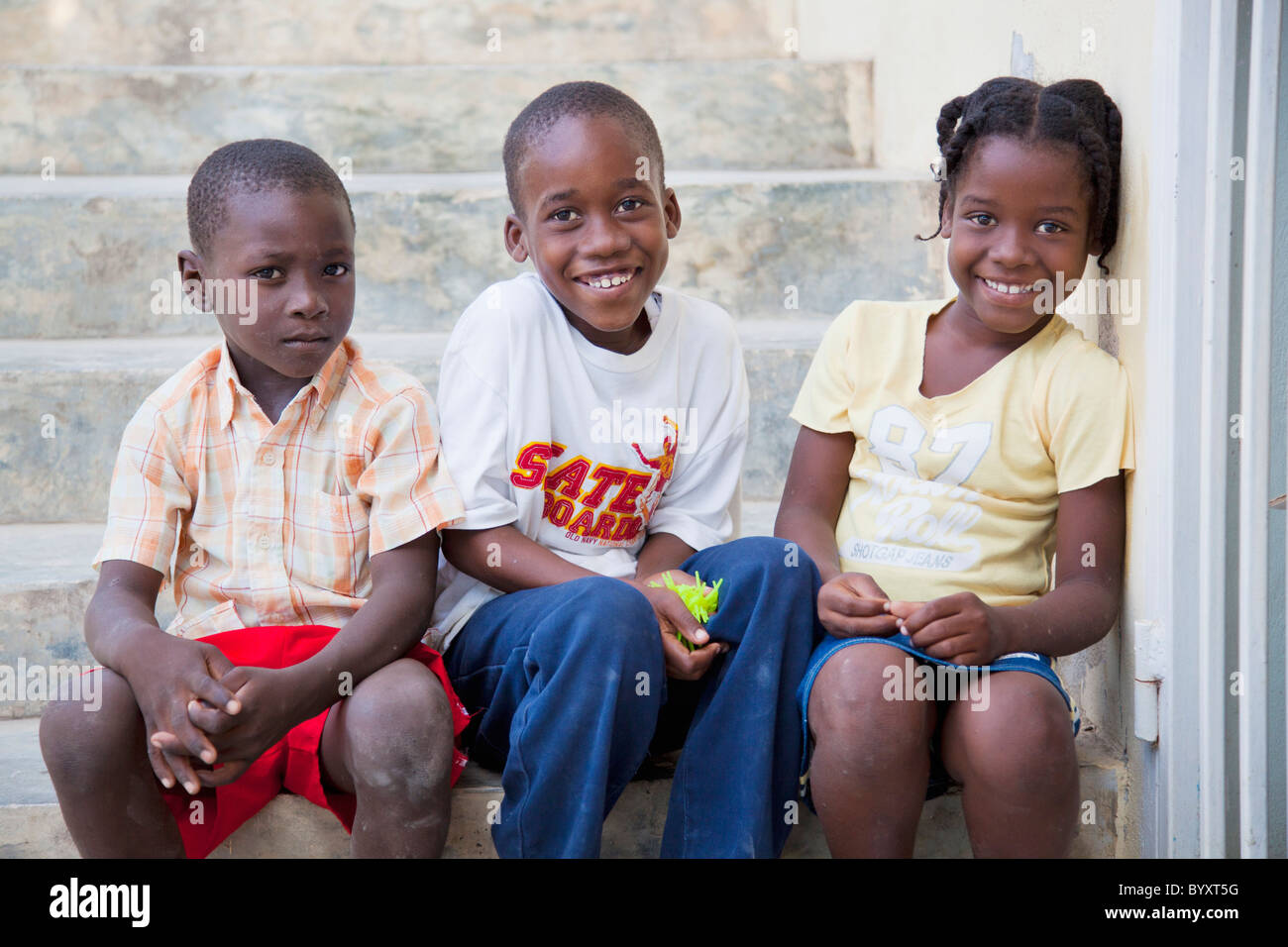 drei Kinder sitzen auf einer Stufe; Grand Saline, haiti Stockfoto