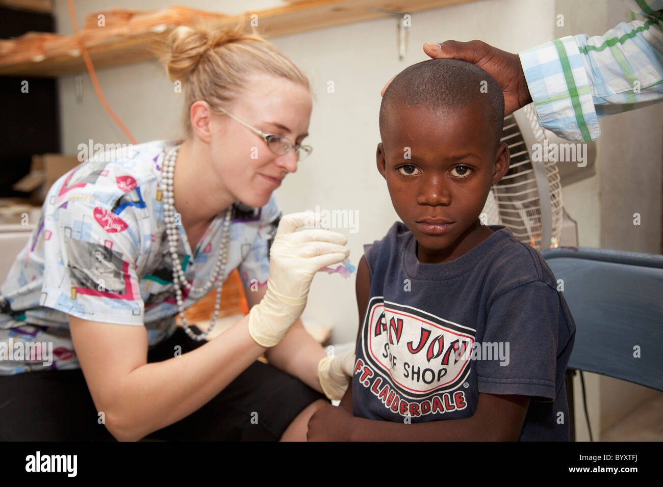 eine Krankenschwester gibt eine Impfung für einem jungen; Grand Saline, haiti Stockfoto