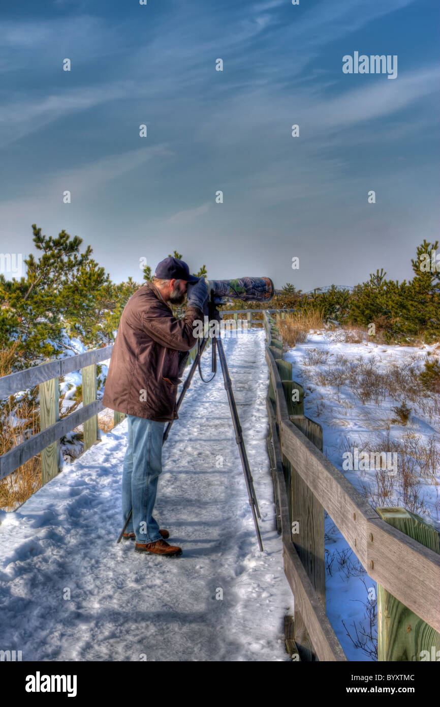 Der Naturfotograf mit großen Objektiv fotografieren auf der Promenade an der Fire Island National Seashore im Winter Stockfoto