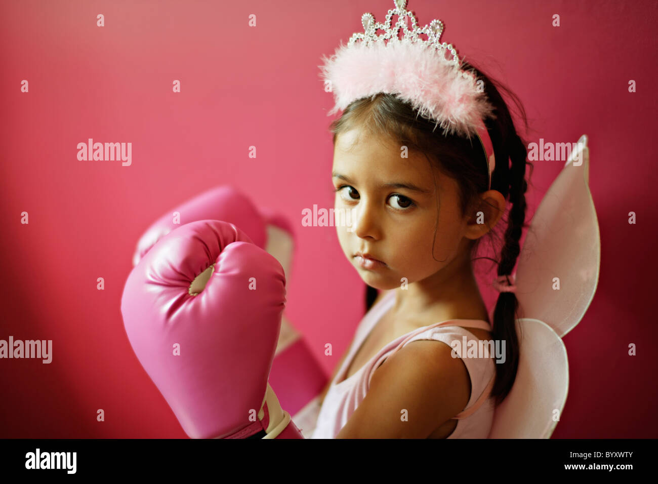 Fünf Jahre altes Mädchen mit rosa Boxhandschuhe, Feenflügel und tiara Stockfoto