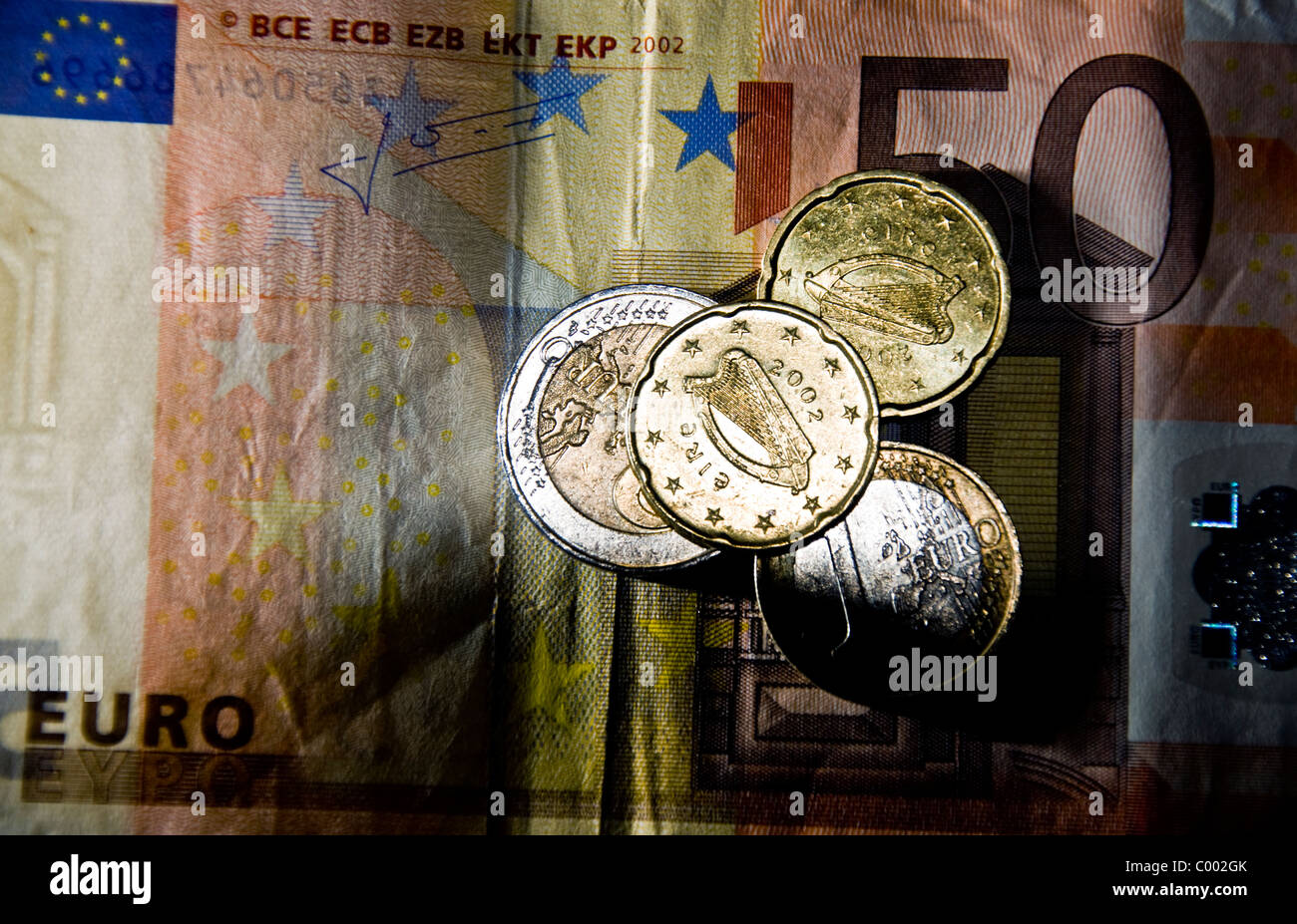Euro-Münzen mit Irish Harp Symbol ruhen auf einem 50 Euro-Schein Stockfoto