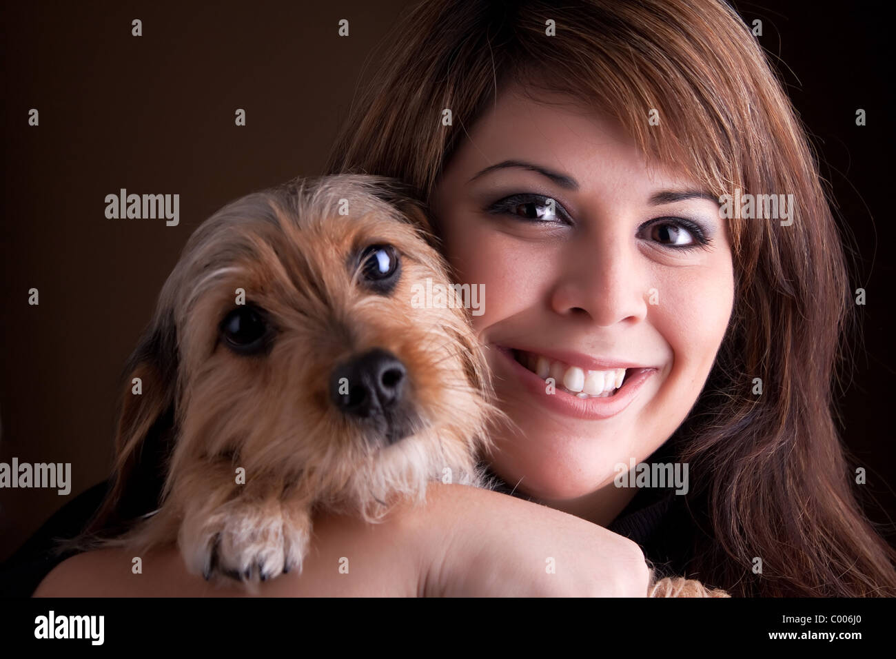 Eine junge Frau in ihrem 20 s hält eine süßen Mischling Beagle Yorkshire-Terrier (auch bekannt als Borkie) Hund. Stockfoto