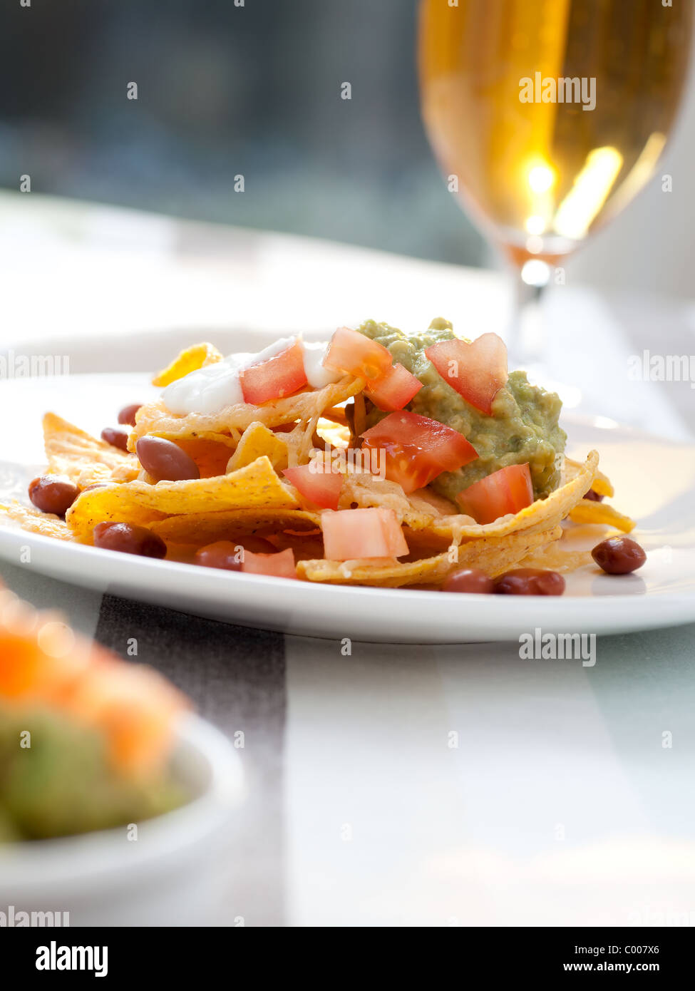 Frische Nacho-Chips mit Bohnen, Tomaten, Käse und guacamole Stockfoto