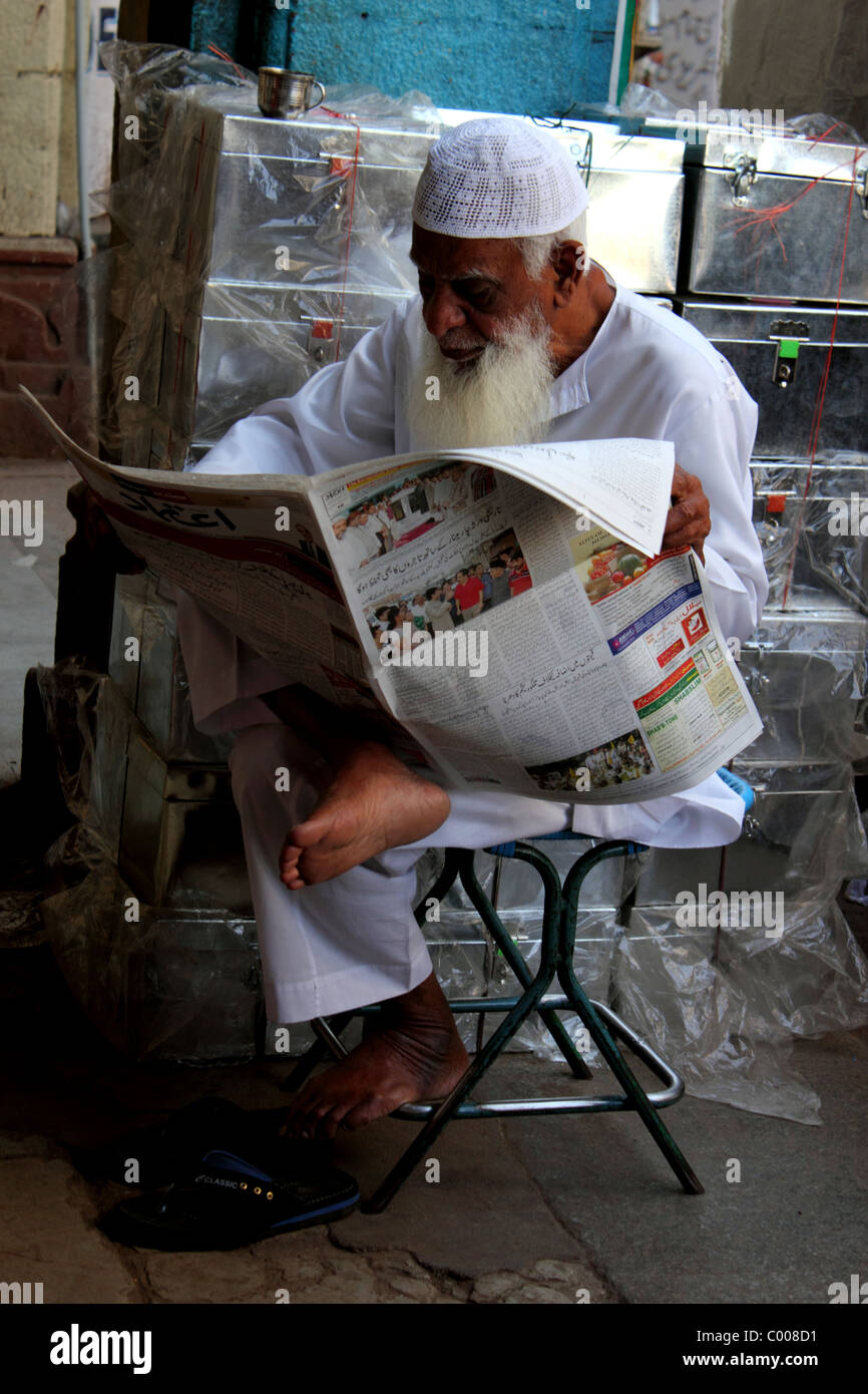Aufrechte Porträt von älteren Menschen muslimischen Mann mit langen, weißen Bart Zeitunglesen in Hyderabad Indien in der Nähe von Charminar Stockfoto