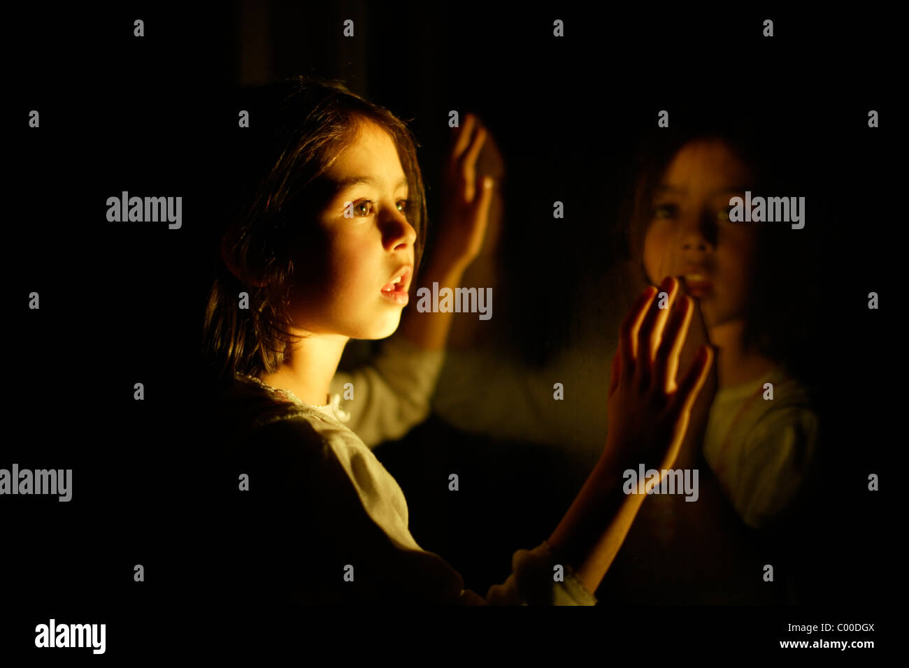 Mädchen in der Nacht mit Fenster Reflexion Stockfoto