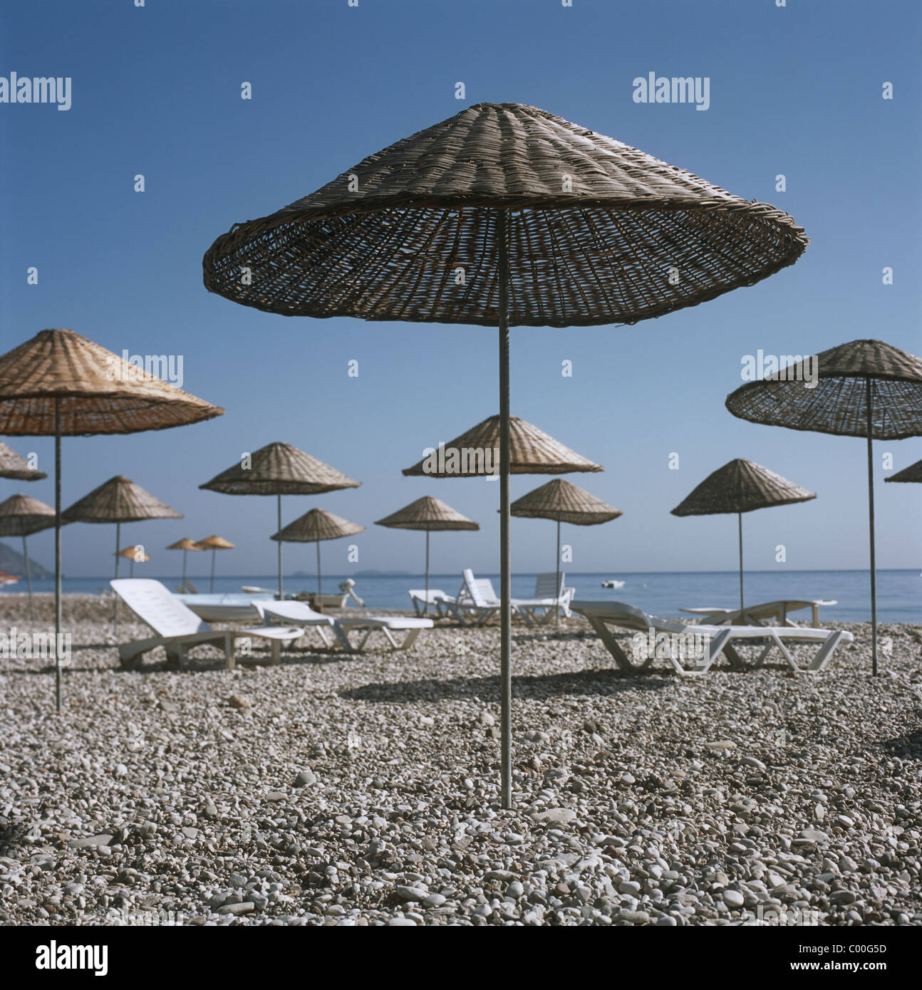 Palapas und Liegestühle am Strand Stockfoto