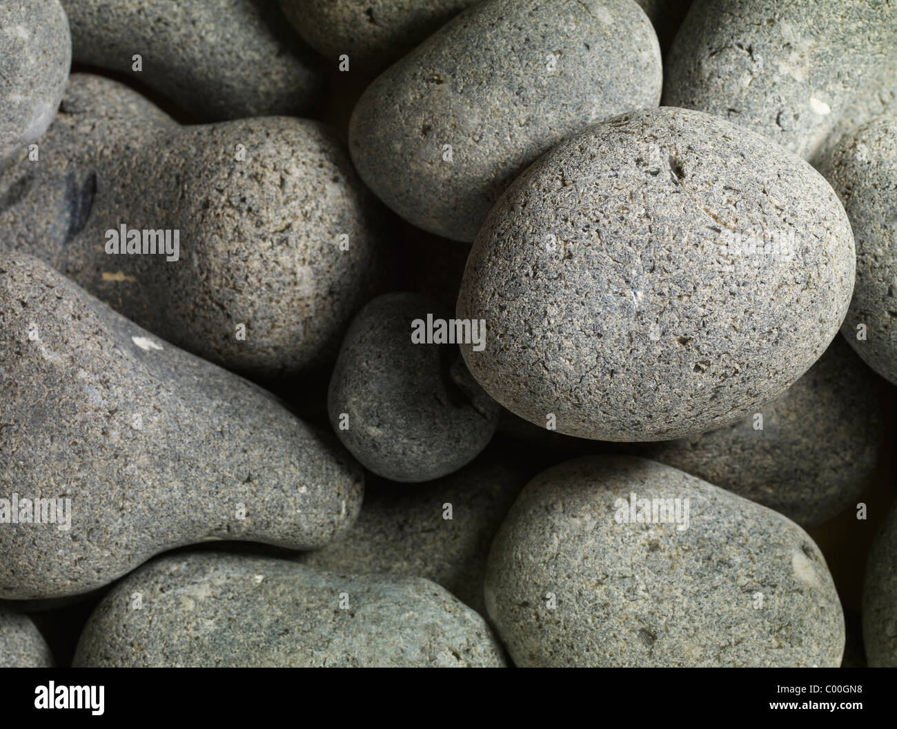Granitkiesel, rund und glatt, bilden einen abstrakten Hintergrund Stockfoto
