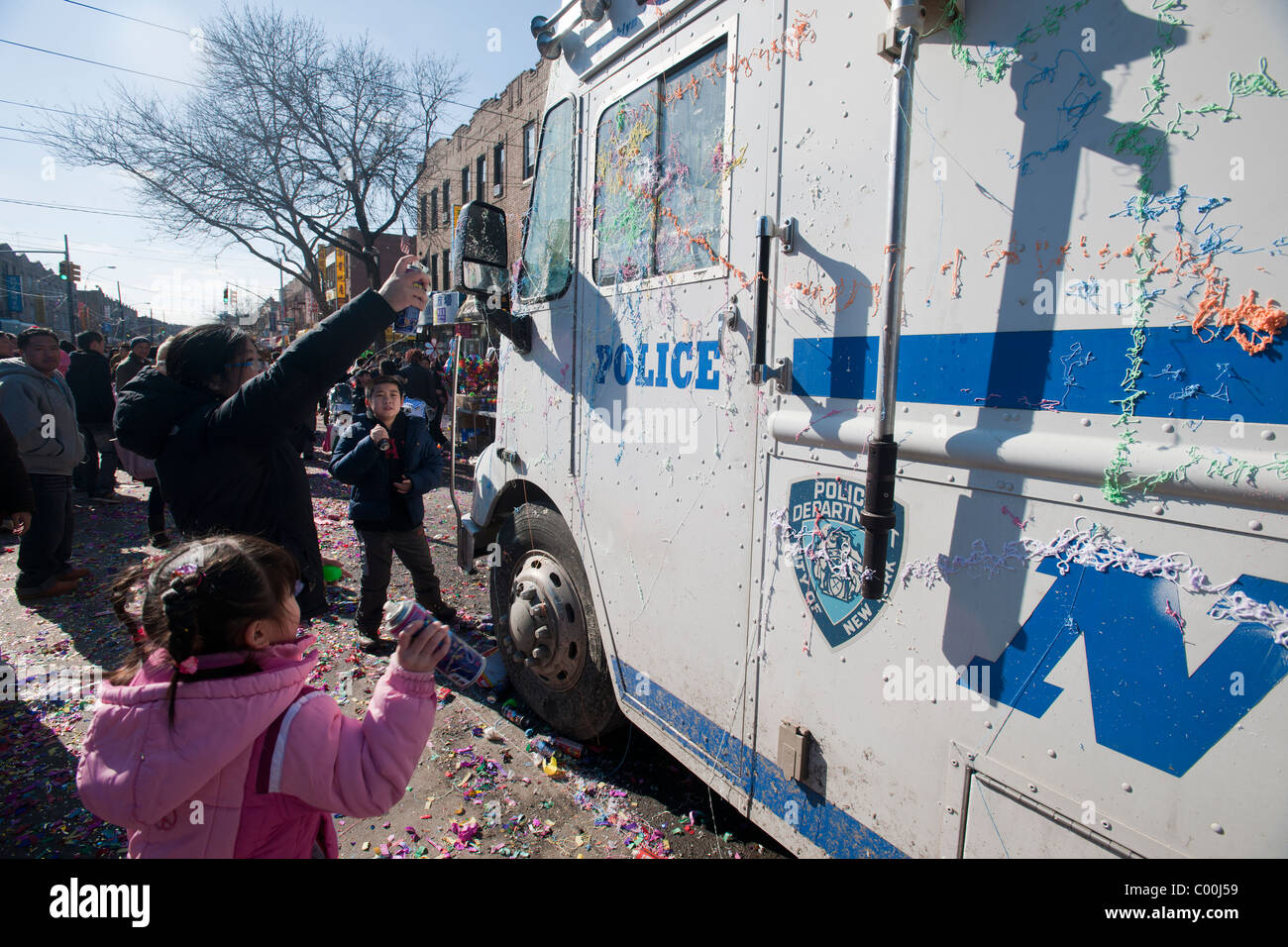 Kinder sprühen 'Silly String' auf ein Polizeifahrzeug als Glücksbringer in der Nähe von Sunset Park in New York Stockfoto