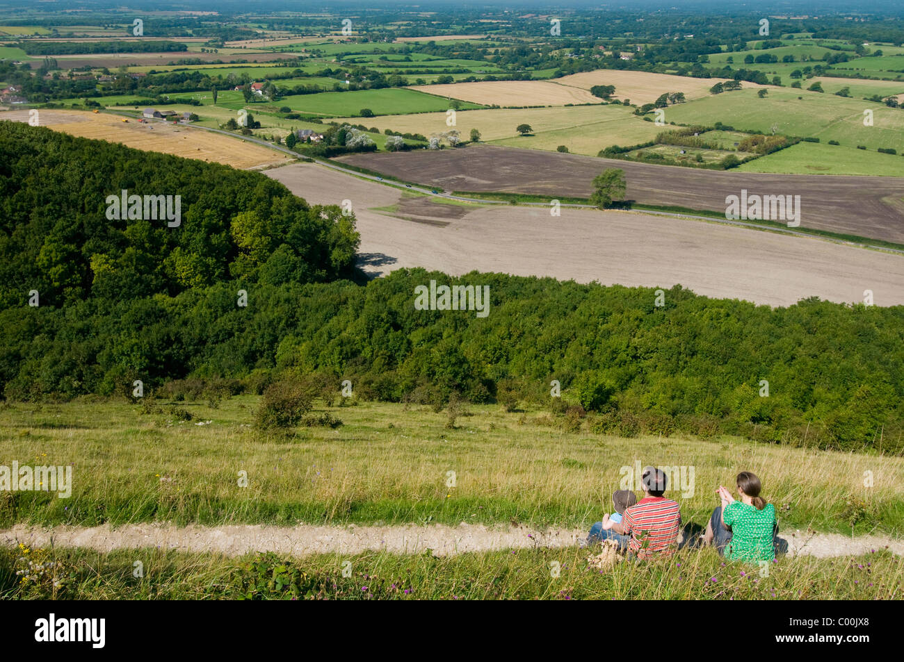 Paar mit Junge sitzt auf Hügel am Deich des Teufels in der Nähe von Brighton Stockfoto
