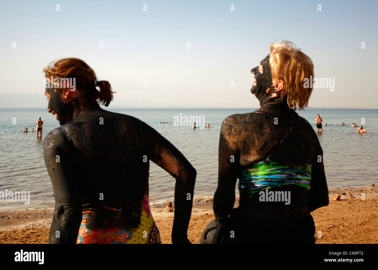 Menschen bedeckt mit Schlamm am Toten Meer, Jordanien. Stockfoto