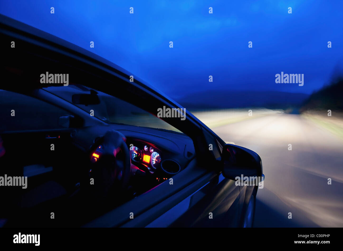 Auto unterwegs in der Abenddämmerung Stockfoto