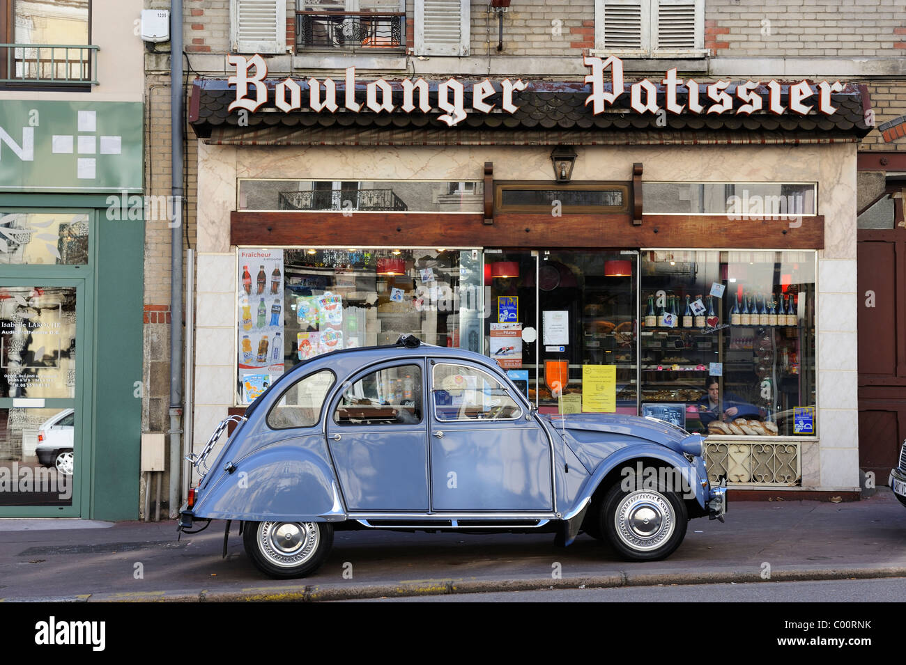 Stock Foto von einem blauen Citroen 2CV geparkt vor einem Boulanger-Geschäft in Limoges, Frankreich. Stockfoto