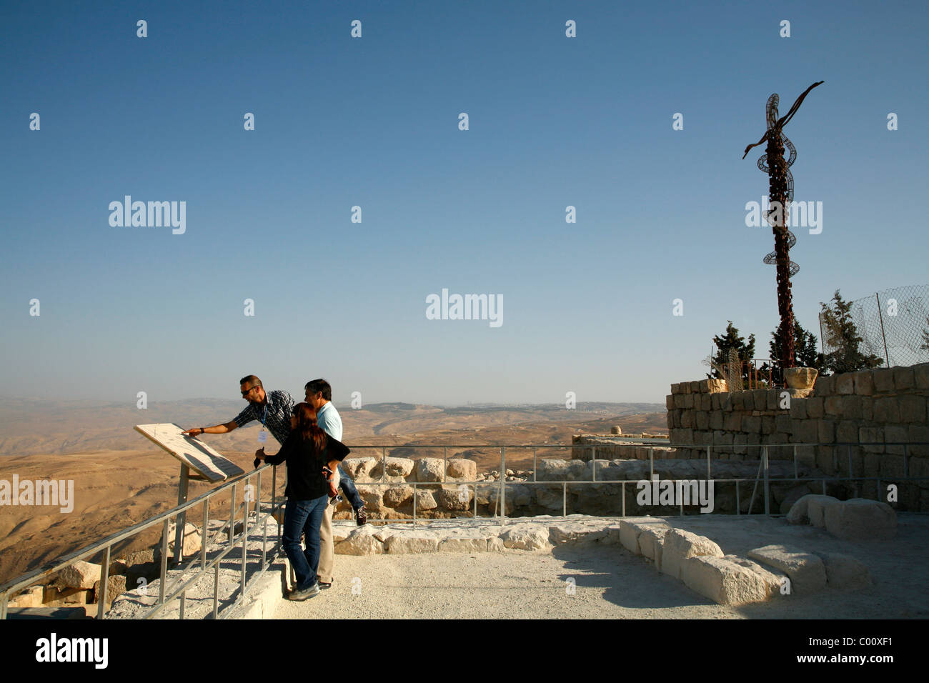 Touristen am Berg Nebo mit Gedenkkreuz hinter Jordan. Stockfoto
