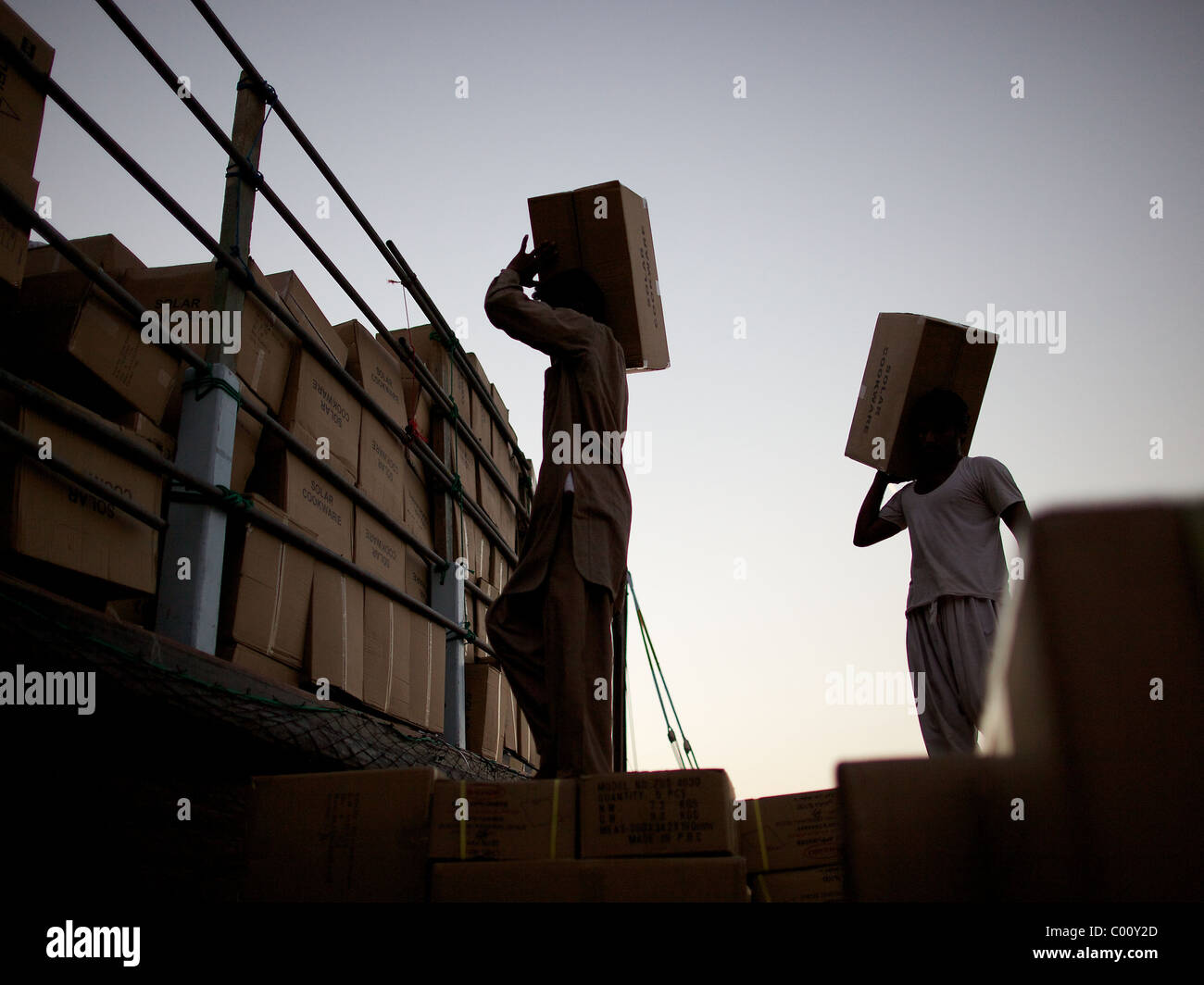 Arbeiter laden traditionelle Dhaus nach Sonnenuntergang am Dhau Kaianlage in The Creek, Dubai, Vereinigte Arabische Emirate Stockfoto