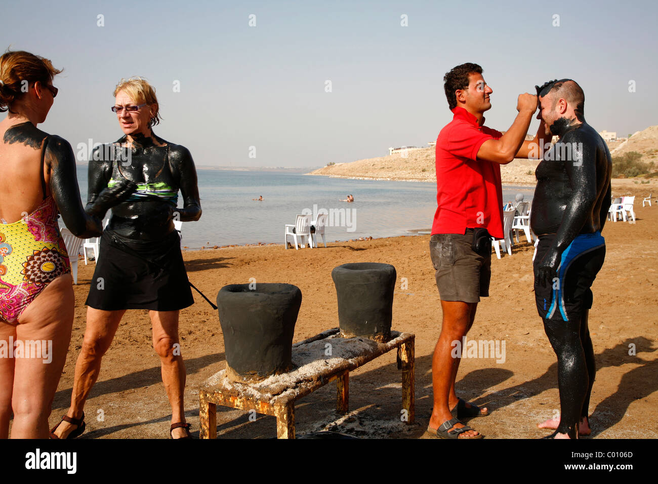 Menschen bedeckt mit Schlamm am Toten Meer, Jordanien. Stockfoto