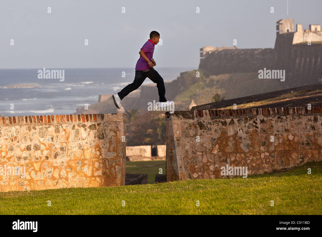 Ein kleiner Junge läuft entlang der alten Stadtmauer von San Juan, Puerto Rico. Stockfoto