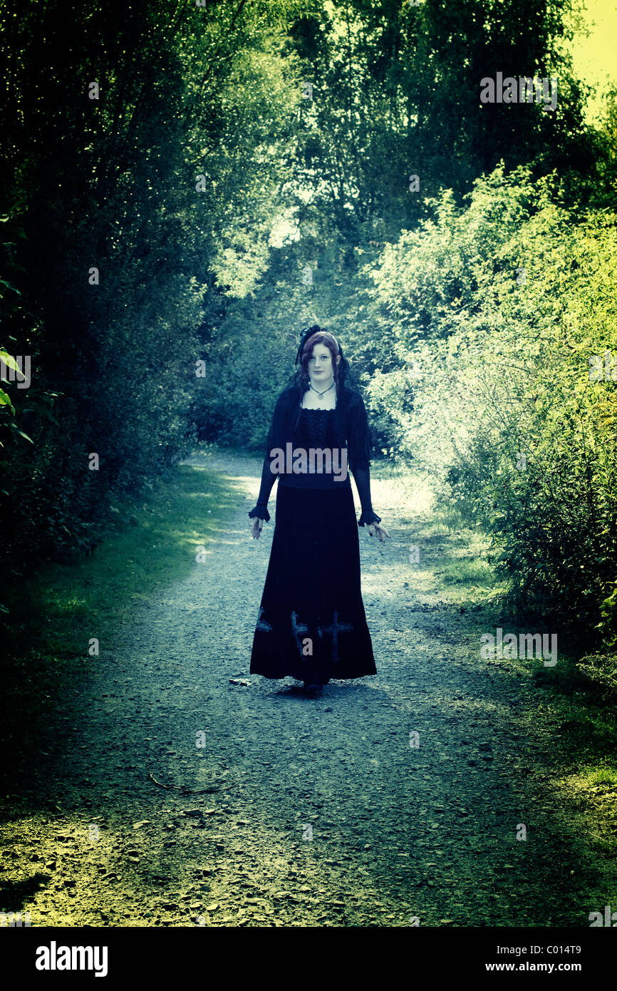 Rothaarige Frau, Gothic, zu Fuß auf einem Weg, retro Stockfoto