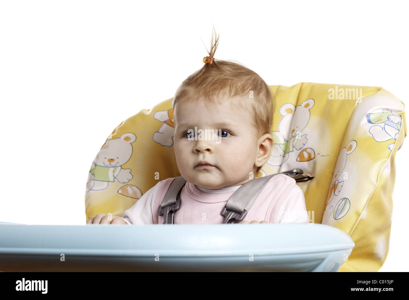 Babymädchen mit Haarnadelkurven auf Hochstuhl sitzt. Stockfoto