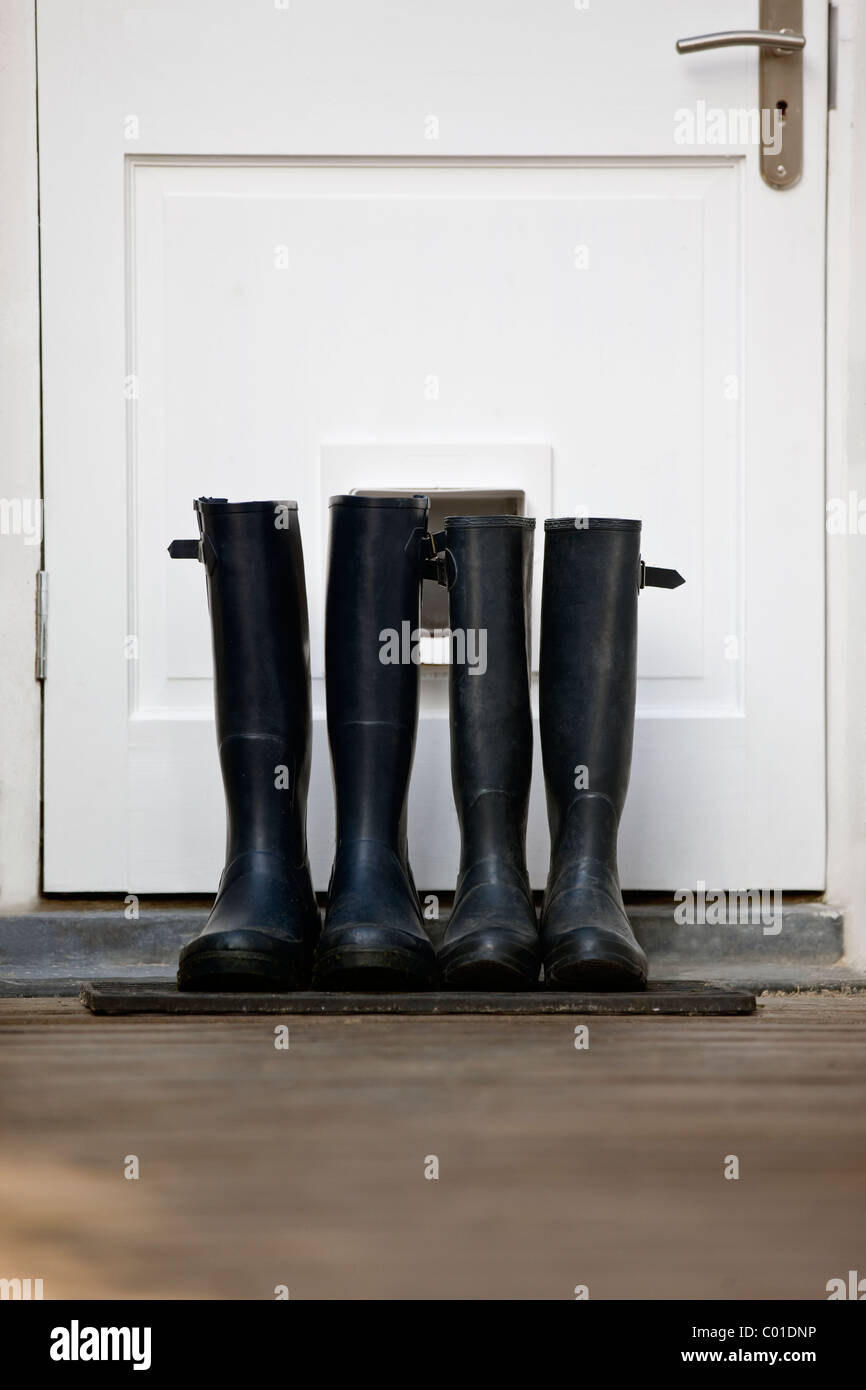 Zwei Paar Gummistiefel durch eine Tür Stockfoto