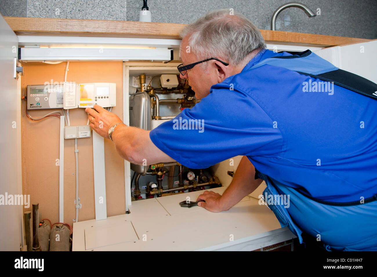 Heizungs- und Sanitär-Techniker testen und Einstellen der Bezirk Heizung  Steuerung Stockfotografie - Alamy