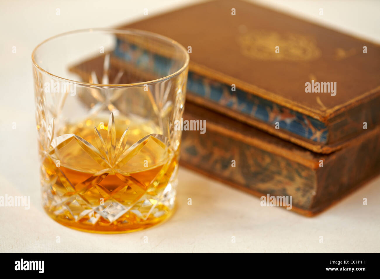 Glas von Malt Whisky und alte antiquarische Bücher Stockfoto