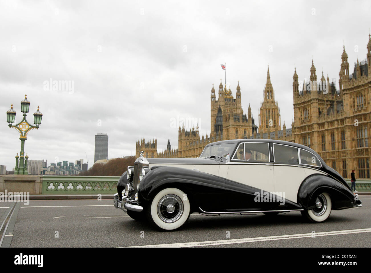 Ein Rolls-Royce Silver Wraith fährt vorbei den Houses of Parliament in London, England Stockfoto