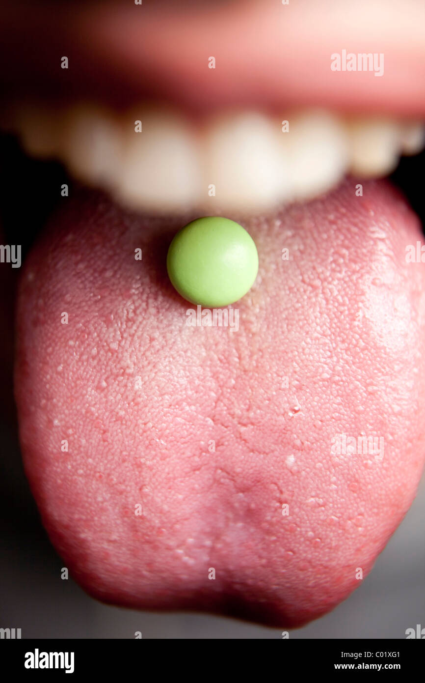 Tablette, Pille auf eine Zunge, Mund Stockfoto