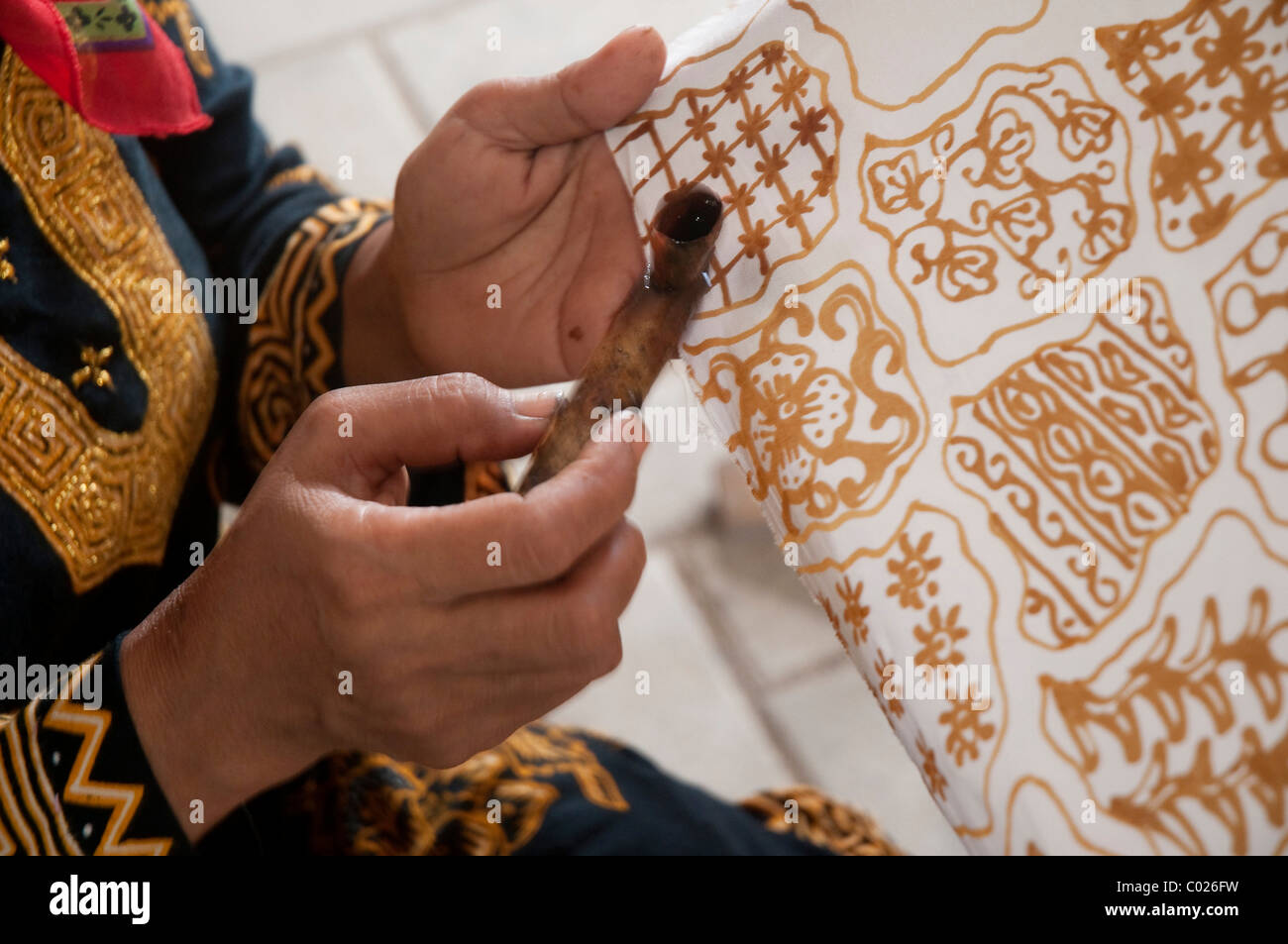 eine Frau zieht Batik-Muster Stockfoto