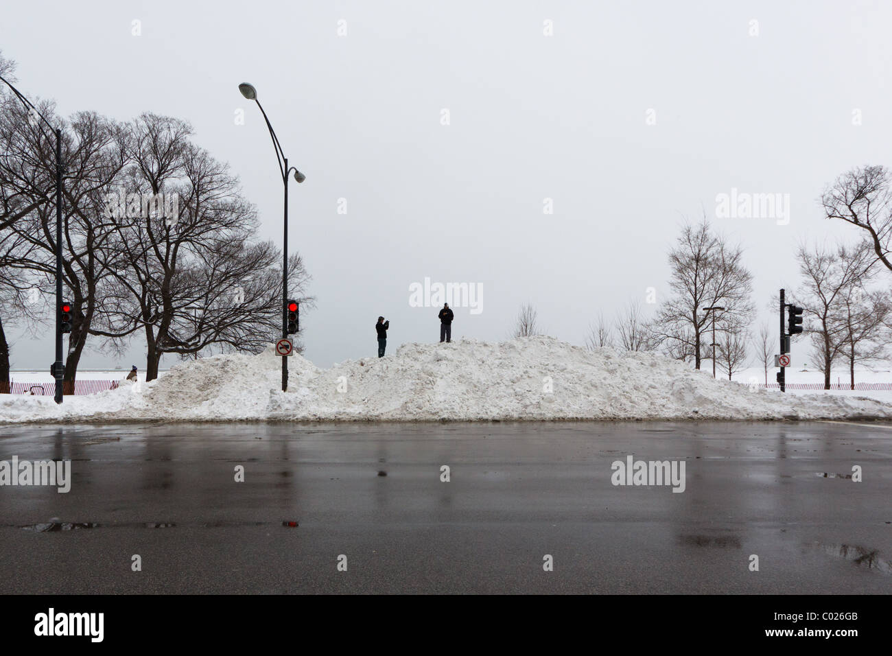 Menschen stehen auf einem Schneehaufen am Lake Shore Drive nach 2011 Chicago Blizzard Stockfoto