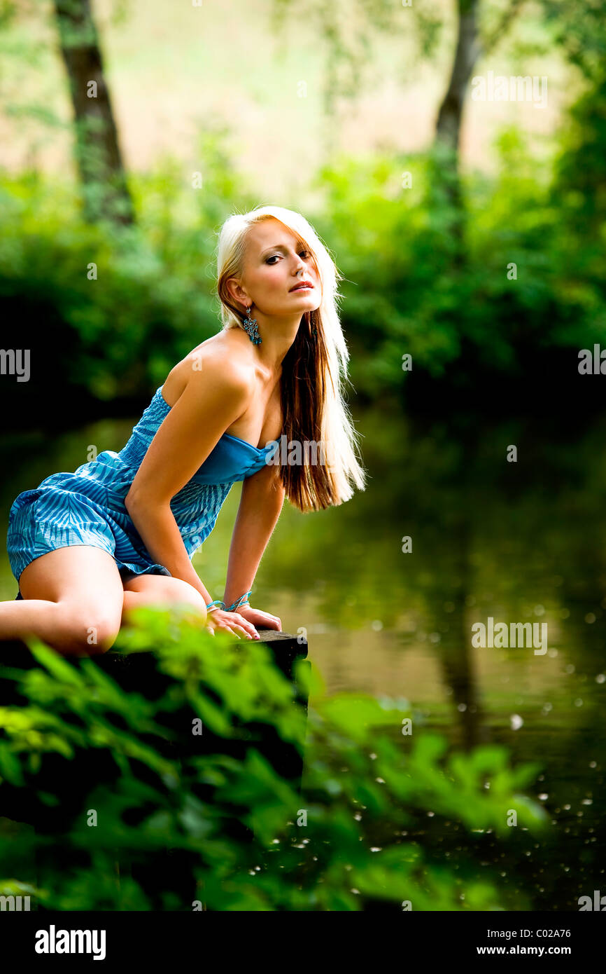 Junge Frau an einem Waldsee Stockfoto