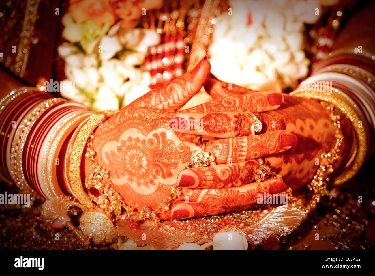 Eine indische Braut mit traditioneller Henna (aka Mehndi)-Farbe, die ihre Arme und Hände bedeckt, an ihrem Hochzeitstag in Neu-Delhi in Indien. Stockfoto