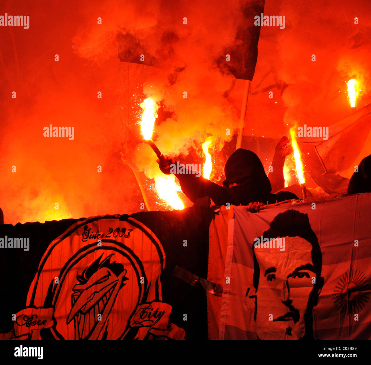 Gewalttätig, maskierten Fans zünden Fackeln in einem Stadion-Fan-block Stockfoto