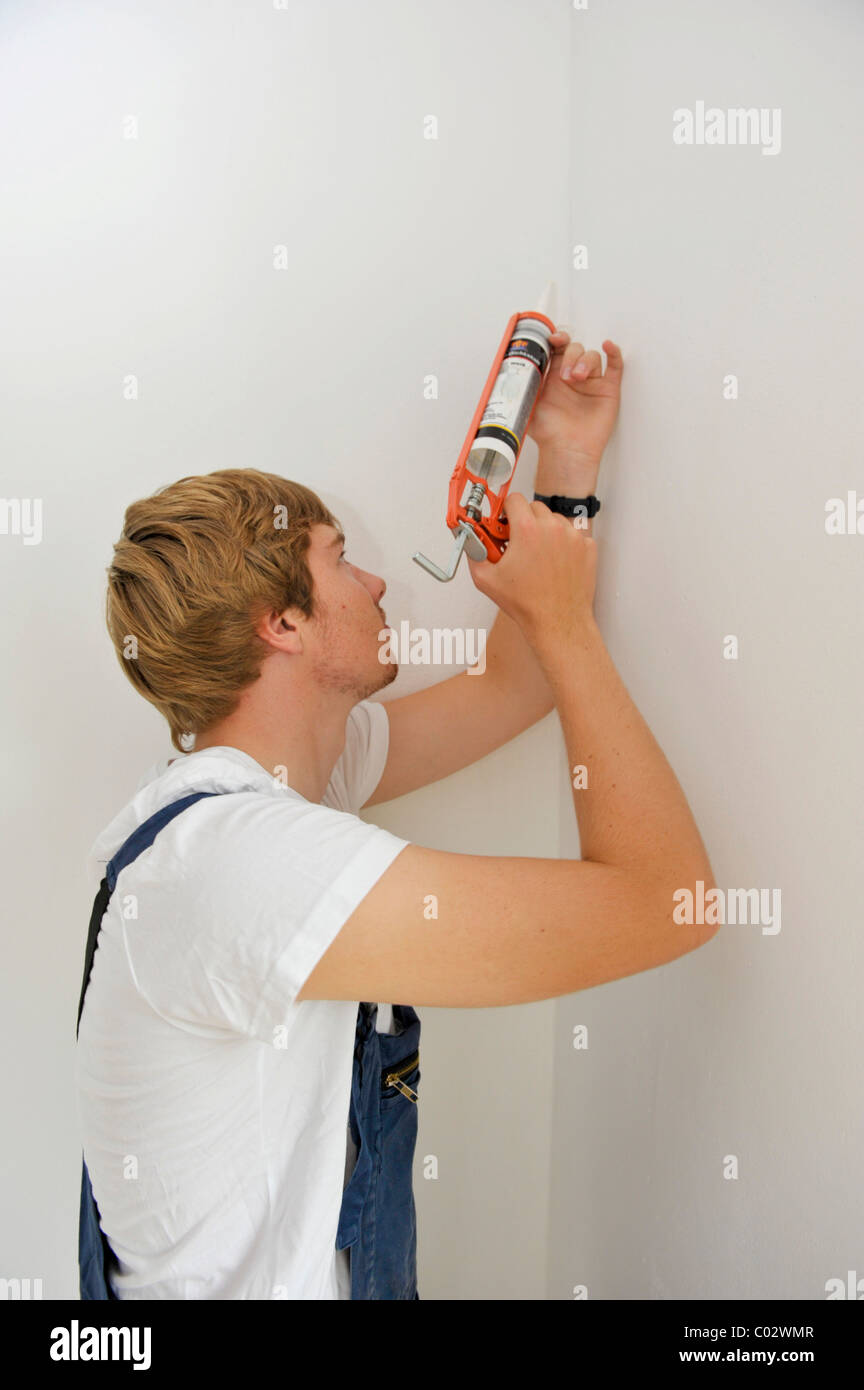 Junger Mann ausbessern Risse mit Acryl Füller Stockfoto