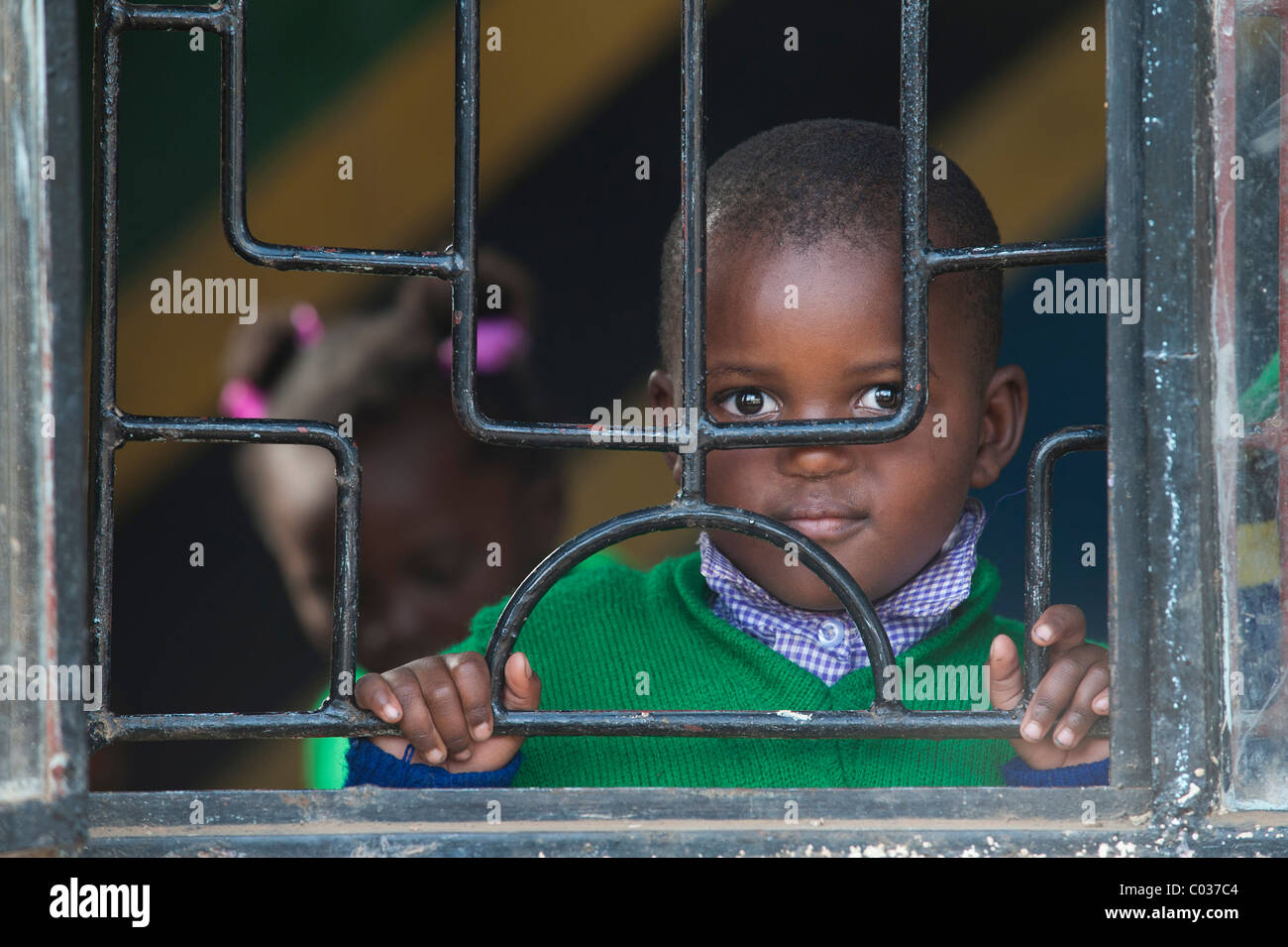 Junge, 4-5 Jahre, Blick durch vergitterten Fenstern, afrikanischen Kindes, Portrait, Tansania, Afrika Stockfoto