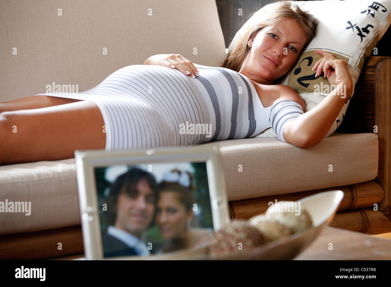 Schwangere Frau mit Hochzeitsbild auf dem Tisch zur Festlegung Stockfoto