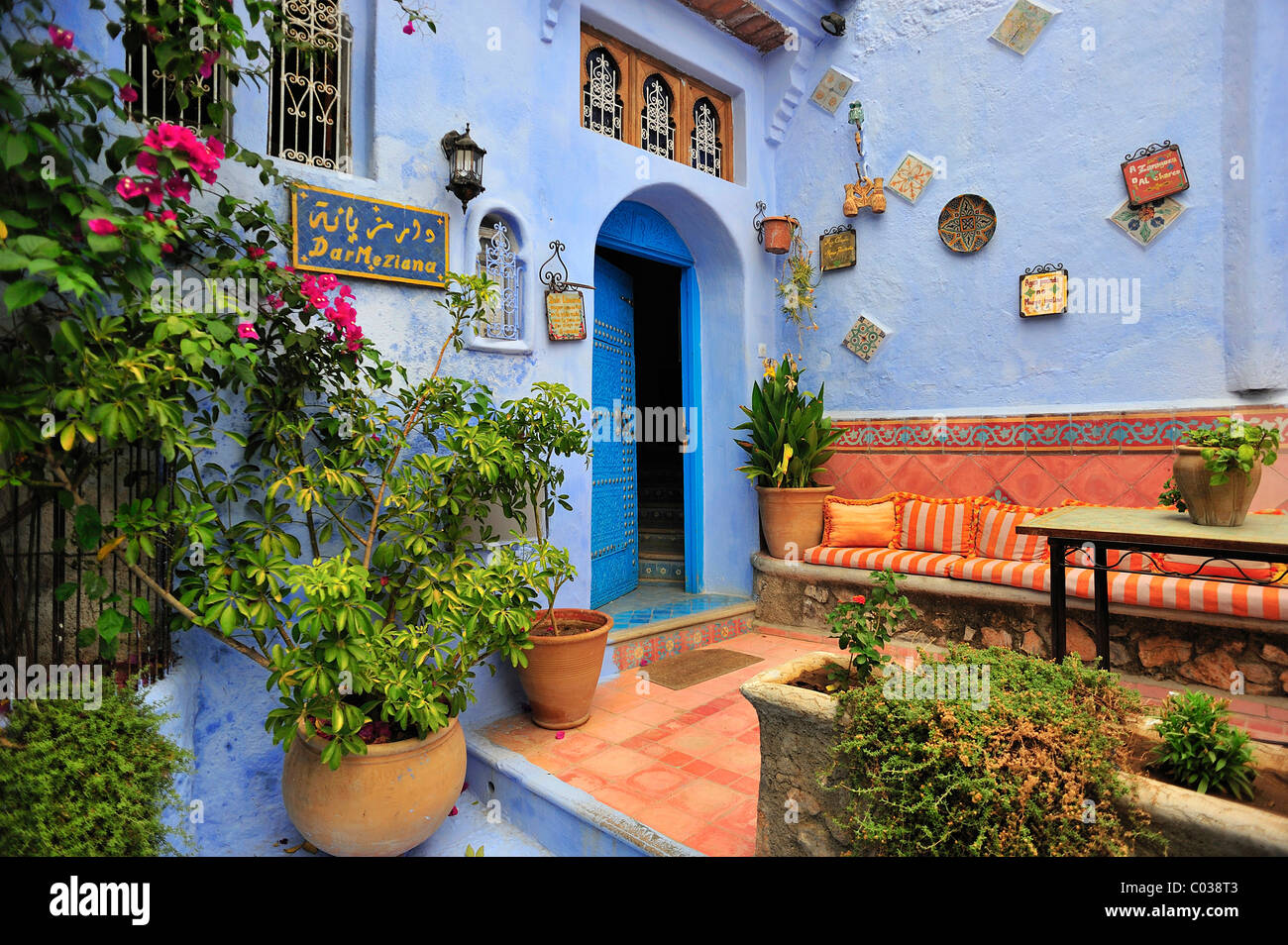 Haustür eines Hauses mit einem Sitzbereich und Pflanzen, Chefchaouen, Riff Bergen, Marokko, Afrika Stockfoto